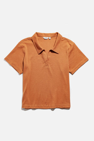 The Avery Boxy Top by Bridge & Burn is a short-sleeved, clay red jersey knit shirt with a collar and V-neck, shown laid flat on a white background.