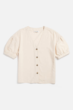 The Charlotte Shirt in Cream Poplin by Bridge & Burn is a short-sleeve V-neck blouse with front buttons, dropped shoulders, and gently puffed sleeves, made from soft Tencel cotton and shown laid flat on a white background.