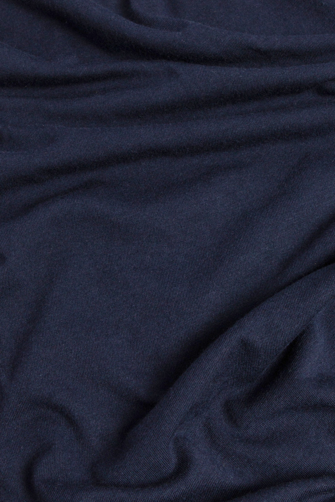 The Bridge & Burn Men's Waves Tee in Navy is made from soft, organic cotton with a smooth texture. Natural folds and gentle creases give this eco-friendly shirt a relaxed, subtly wavy look.