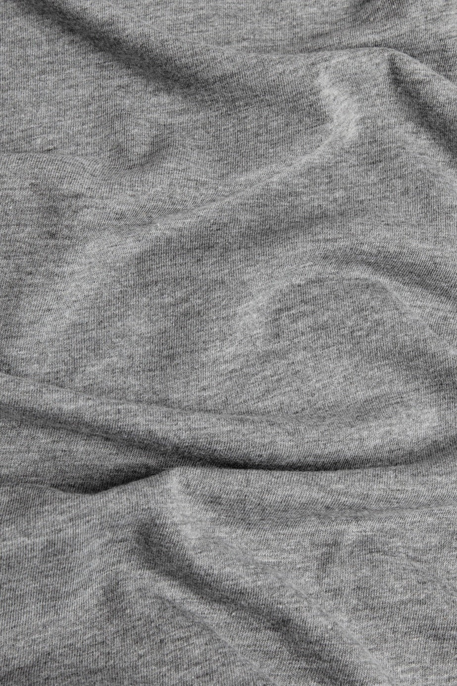 Close-up of the soft, textured surface and gentle folds of the Bridge & Burn Women's Cresting Wave Tee in Grey, made from organic cotton.