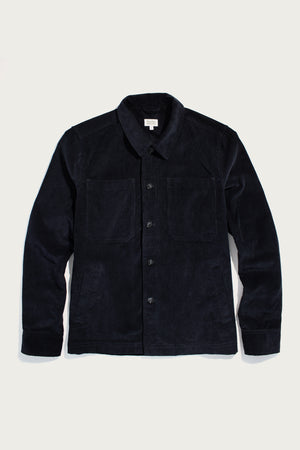 The Bridge & Burn Banks Shirt Jacket in Midnight Blue Corduroy features a collar, long sleeves, button-front closure, and two chest pockets for classic workwear style, shown laid flat on a light background.