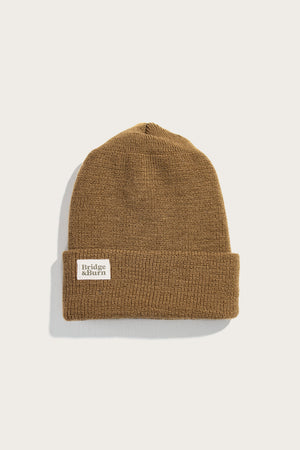 The Bridge & Burn Wool Watch Cap in Coyote is a classic brown knit with a folded brim and a white rectangular front patch, made in the USA and shown against a plain light background.