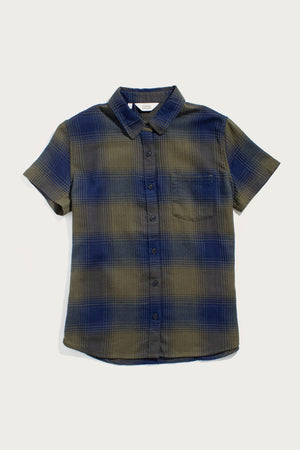 The Bridge & Burn Lana Shirt in Pacific Ombre Plaid features short sleeves, a button-up front, collar, and single chest pocket in blue and olive plaid organic cotton, shown on a plain white background.