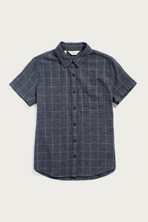 The Bridge & Burn Lana Shirt in Slate Textured Windowpane is a short-sleeve, dark gray organic cotton button-up with a white plaid pattern, pointed collar, and left chest pocket, shown on a plain white background.