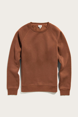 The Lincoln Crew Sweatshirt by Bridge & Burn in Burnt Umber is a sustainable, long-sleeve crewneck with ribbed cuffs, shown laid flat on a light background.