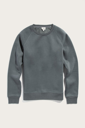 The Bridge & Burn Lincoln Crew Sweatshirt in Slate is a sustainable, plain long-sleeve crewneck with ribbed cuffs, collar, and hem. Laid flat on a light background, it features no patterns or visible logos.