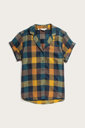 The Bridge & Burn Innes Shirt in Moonbow Plaid features a relaxed fit, short sleeves, collar, and an easygoing style. Made from recycled cotton, it showcases a bold plaid pattern in yellow, blue, brown, and green.