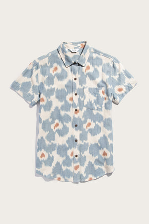 The Bridge & Burn Lana Shirt in Polar Blossom is a relaxed fit, short sleeve button up with a blue, white, and brown abstract print. Made from 100% cotton, it features a classic collar and single chest pocket. Shown against a white background.
