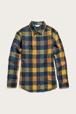 The Olivia Slim Shirt / Moonbow Plaid by Bridge & Burn is a modern long-sleeve button-up featuring a large plaid pattern in yellow, blue, brown, and black on a light background. Made from recycled cotton with a classic collar and front buttons.