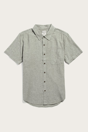The Bridge & Burn Malcolm Shirt in Sage Chambray is a sustainable men's short-sleeve button-up with a collar and single chest pocket, shown in light gray on a plain white background.
