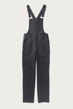 The Bridge & Burn Tobin Utility Overall in dark charcoal canvas features adjustable shoulder straps, metal buckles, a front chest pocket, side buttons, and straight-leg pants laid flat on a white background.
