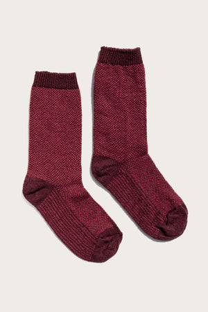 A pair of Bridge & Burn Helix Sock / Burgundy, featuring eco-friendly maroon knit with darker toes, heels, and cuffs, displayed side by side on a light background.