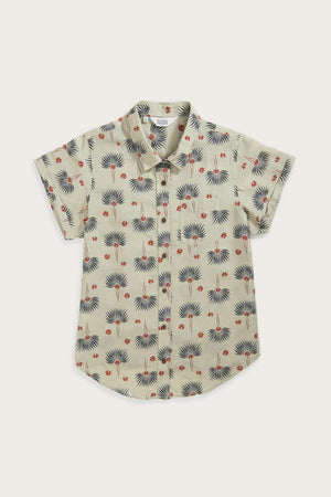 The Bridge & Burn Bea Shirt / Aloha Floral is a short-sleeved linen cotton shirt in light beige, featuring a classic collar and a vibrant blue palm leaf and red cherry-like pattern.