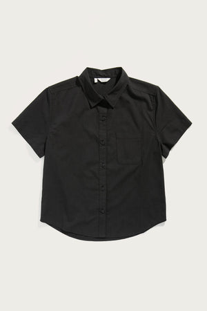The Bridge & Burn Greer Cropped Shirt in black poplin is a boxy-fit, short-sleeve button-up with a single chest pocket, shown laid flat on a white background.
