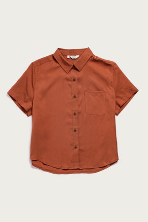 The Bridge & Burn Greer Cropped Shirt in Copper is a short-sleeve Tencel top with a boxy fit, single chest pocket, spread collar, and curved hem, shown laid flat on a white background.