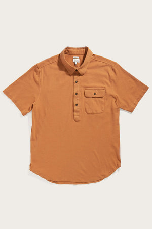 The Bridge & Burn Gary Knit Pullover in Clay Red Jersey is a men's casual short-sleeve polo with a collar, three-button placket, and buttoned chest pocket, crafted from soft jersey knit and shown laid flat on a white background.