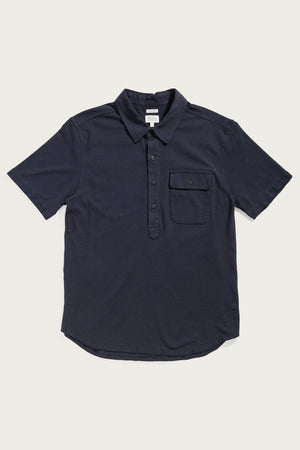 The Bridge & Burn Gary Knit Pullover in navy jersey is a men's short-sleeved summer shirt with a buttoned placket and chest pocket, crafted from soft knit fabric and shown on a plain white background.