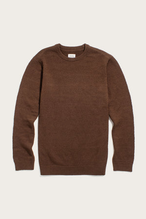 The Bridge & Burn Calder Sweater in Walnut features a sustainable brown knit with a subtle textured pattern, long sleeves, and ribbed cuffs, collar, and hem, shown flat on a cream background.