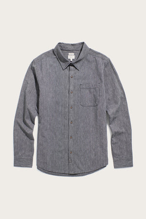 The Bridge & Burn Jude Shirt in Onyx Stripe is a classic fit men's button-up made from 100% cotton with a dark gray textured stripe, featuring a collar, single chest pocket, and brown buttons, shown flat on a light background.