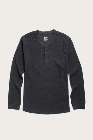 The Bridge & Burn Men's Recycled Waffle Henley in Charcoal Melange is a long-sleeve shirt made from sustainable fibers, featuring a round neckline and three-button placket, shown laid flat on a light background.