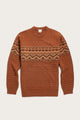 The Bridge & Burn Rockwood Fairisle Sweater in Walnut Grove is a rust-colored merino wool knit with a crew neck, long sleeves, and a beige and brown geometric fairisle pattern across the chest and upper arms.