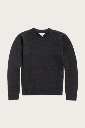 The Bridge & Burn Ansel Sweater in Midnight is a dark charcoal gray, mid-weight crewneck made from recycled fibers with a simple knit pattern, shown laid flat on a light background.