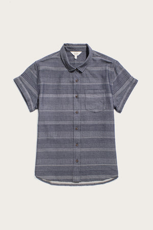 The Bea Shirt / Cascade Weave by Bridge & Burn is a tailored, short-sleeve button-down in blue-gray with subtle stripes and a chest pocket, made from organic cotton and pictured flat on a white background.