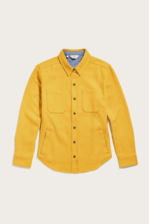 The Bridge & Burn Dawson Overshirt in Antique Gold is a sustainable, heavyweight layer made from recycled cotton, featuring long sleeves, chest pockets, a pointed collar, and angled side pockets—shown on a plain white background.