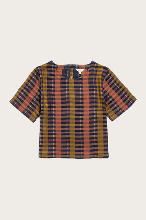 The Leona Shirt by Bridge & Burn features a short-sleeved, boxy fit and boat neckline in the Alpenglow Stripe pattern with mustard yellow, navy blue, and orange tones, shown on a plain background.