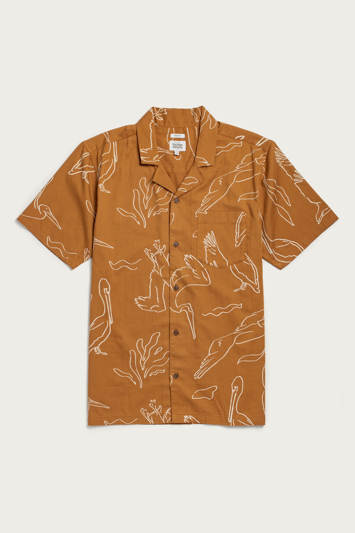 The Bridge & Burn Bodie Shirt / Shoreflight is a lightweight brown summer shirt with short sleeves, retro camp collar, white bird and plant line art, relaxed fit, button-up front, and a single chest pocket.