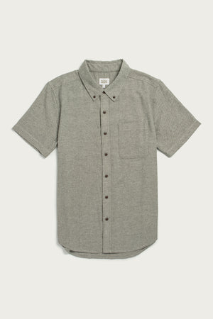 The Bridge & Burn Bryce Shirt in Olive Twill is a short sleeve, button-down men’s shirt with a left chest pocket, made from recycled cotton for sustainability, shown laid flat on a white background.