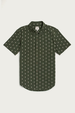 The Bridge & Burn Harbor Slim Shirt in Thyme Arrows is a short-sleeve, dark green button-up with light geometric patterns, crafted from summerweight cotton and finished with a chest pocket and rounded hem for easy style.