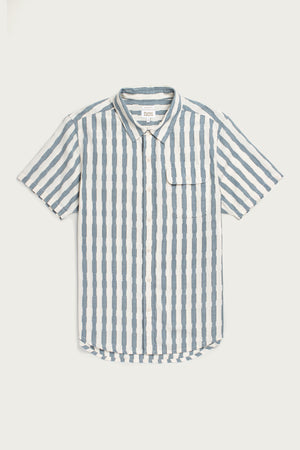 The Bridge & Burn Marten Shirt in Beach Stripe is a cotton, short sleeve button-down with blue and white vertical stripes, a chest pocket, and curved hem, shown on a white background.