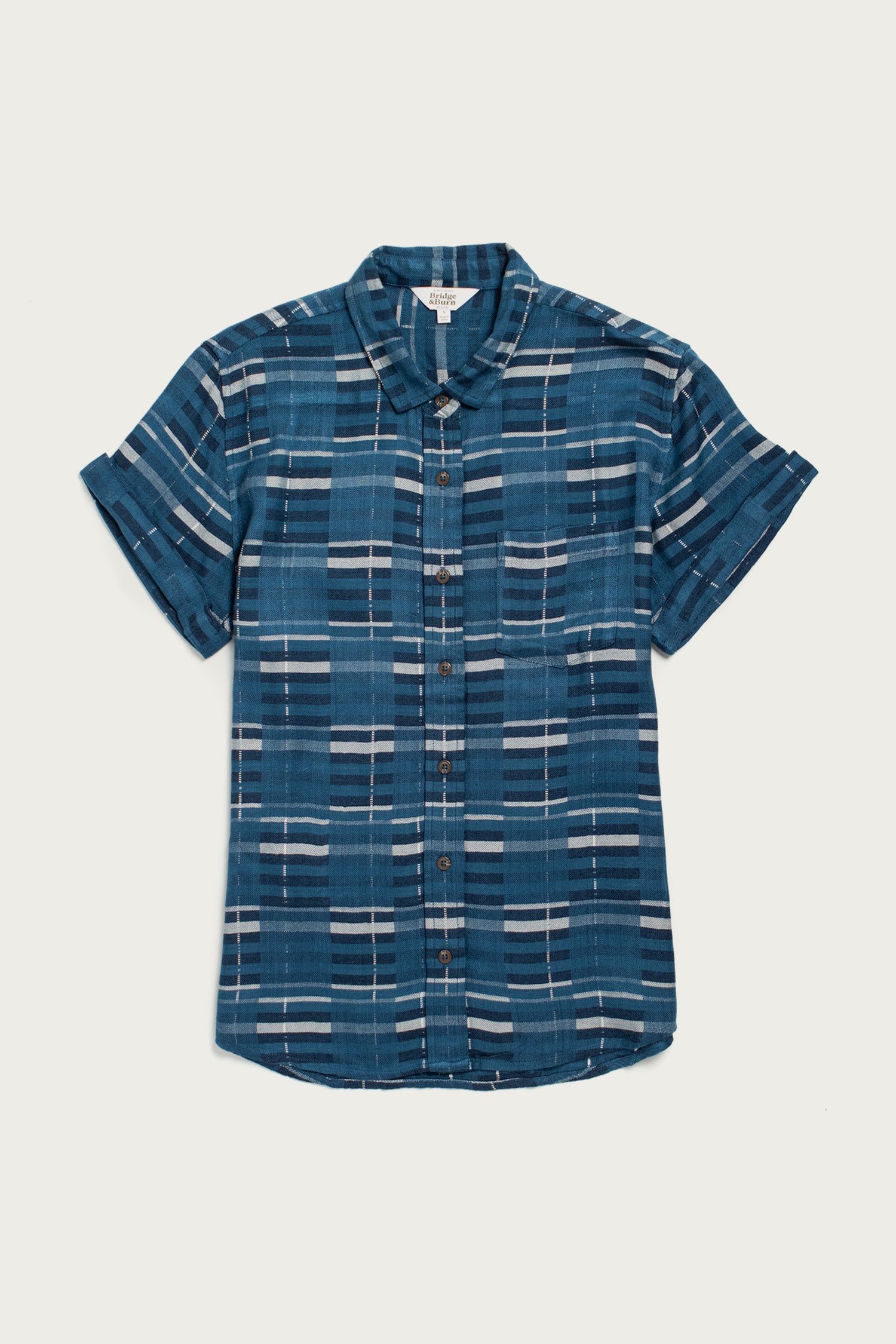 The Bridge & Burn Bea Shirt in Stormcrest Stripe features a blue base with white and gray stripes, a classic collar, short sleeves, and rolled cuffs. Displayed flat on a light background.