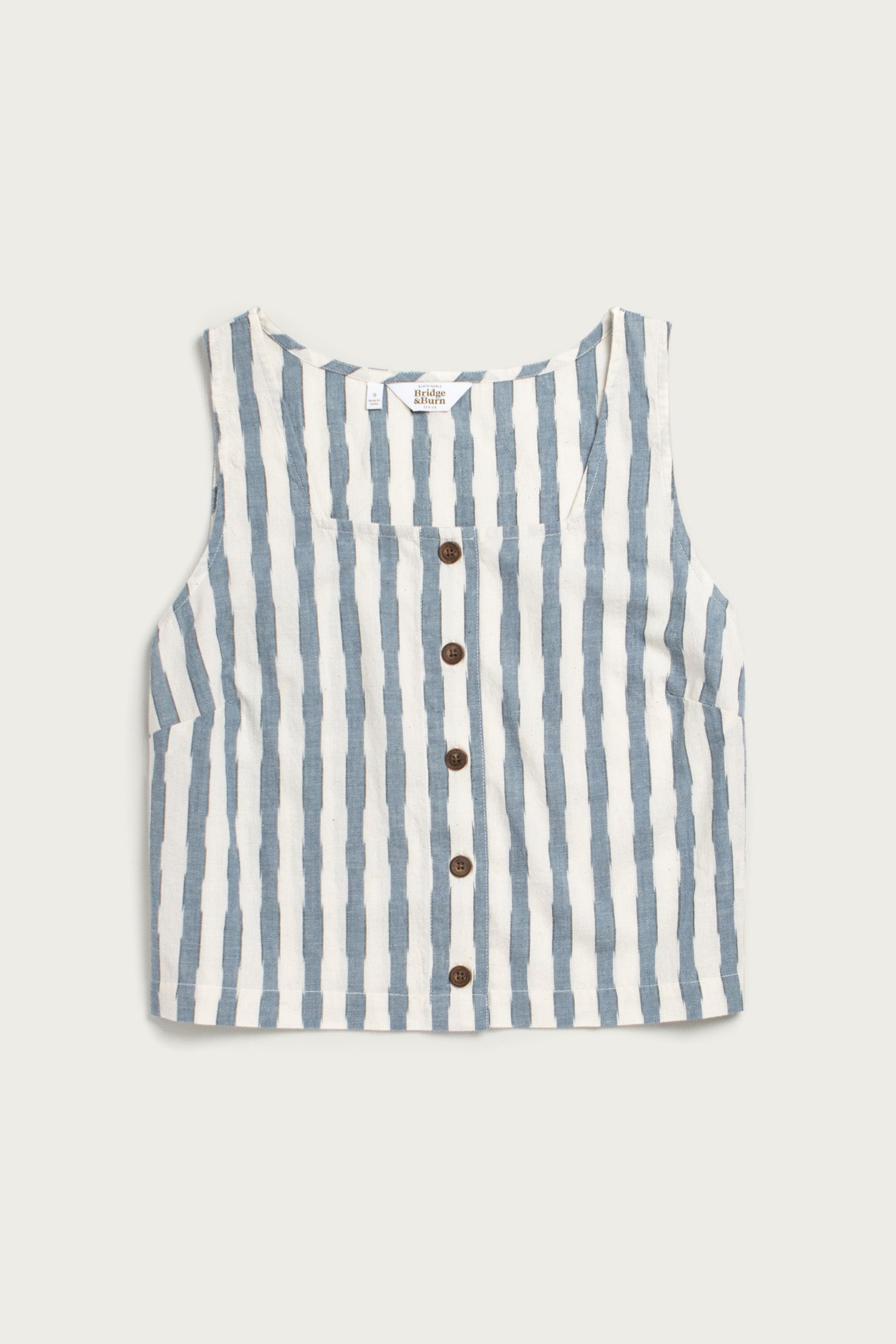 The Sadie Tank in Beach Stripe by Bridge & Burn is a sleeveless, boxy top with vertical blue and white stripes, a round neckline, and brown center buttons for an easygoing style.