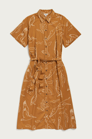 The Sylvie Dress / Shoreflight by Bridge & Burn is a relaxed fit, short-sleeved brown shirtdress with a matching waist tie, featuring a white line-drawn bird and plant pattern for effortless style.