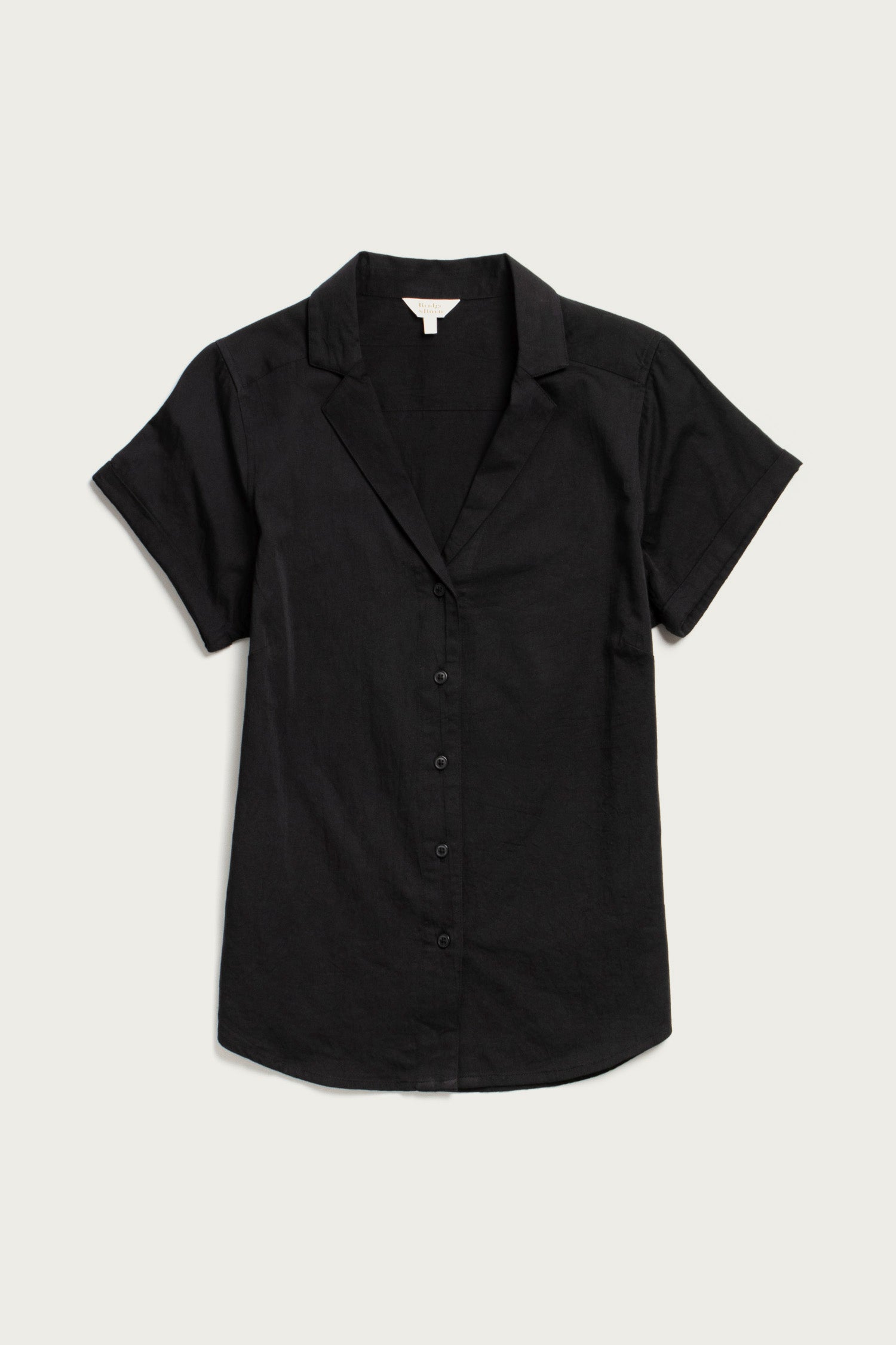 The Bridge & Burn Innes Shirt in black is a relaxed fit, short-sleeve button-up blouse with a collar, crafted from soft organic cotton and shown flat on a light background.
