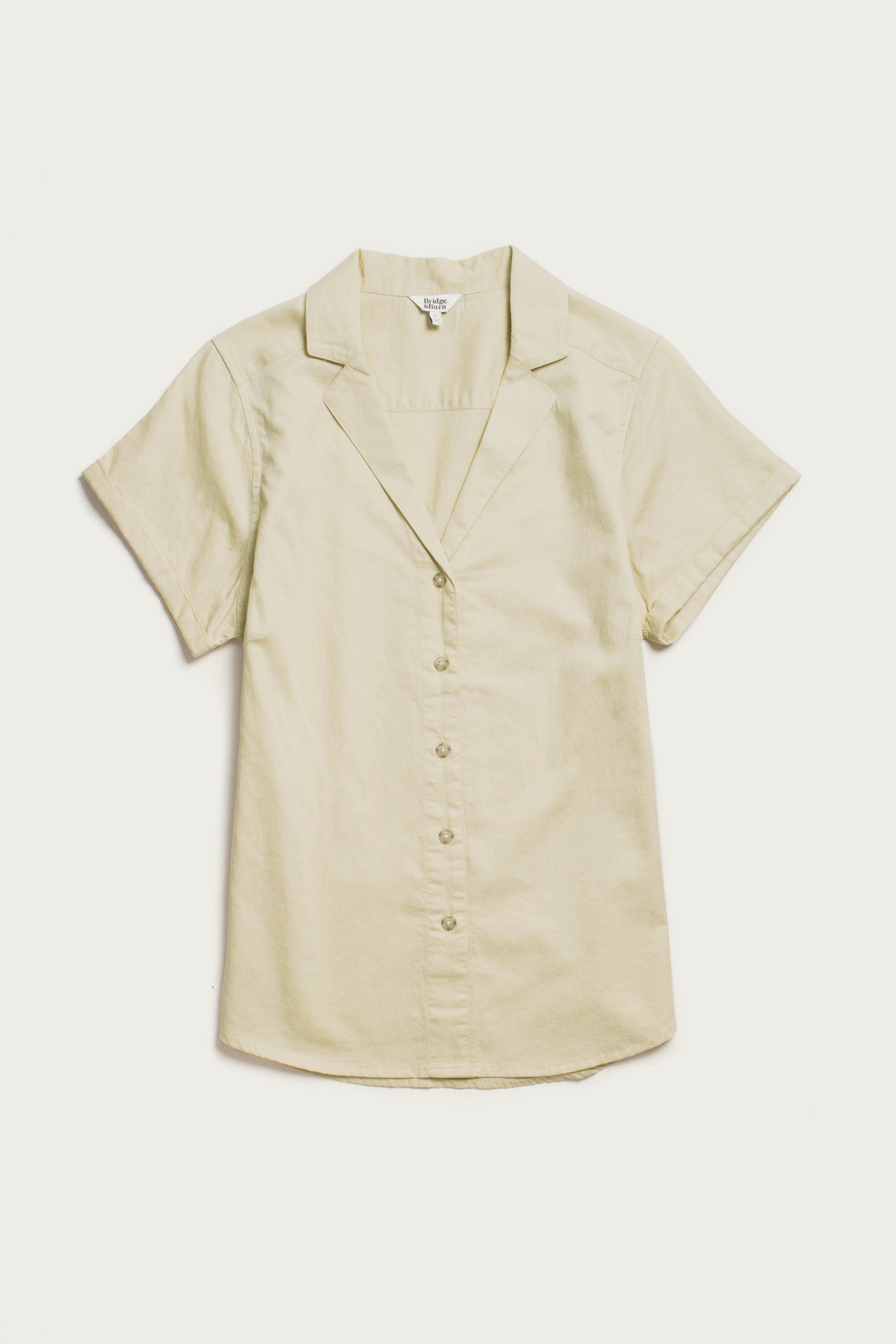 The Bridge & Burn Innes Shirt in Ivory is a relaxed fit, short-sleeve button-up with a notched collar, made from organic cotton and shown laid flat on a white background.