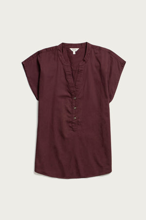 The Bridge & Burn Ladd Shirt in Burgundy is a short-sleeve, organic cotton blouse with a V-neckline, partial button placket, and relaxed fit, shown laid flat on a light background.