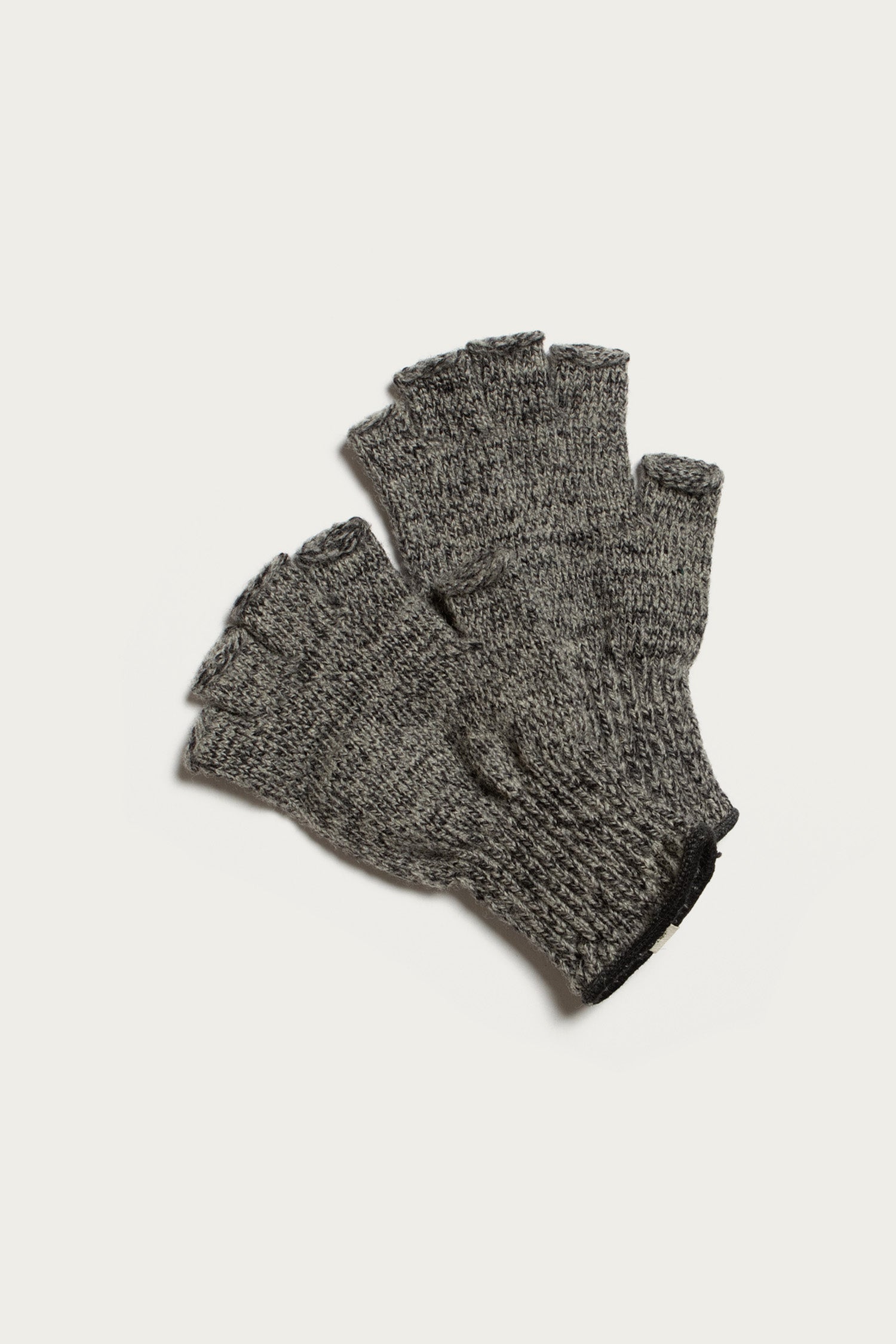 A pair of Bridge & Burn Ragg Wool Fingerless Gloves in Charcoal is laid flat on a white background, highlighting their cozy knit design.
