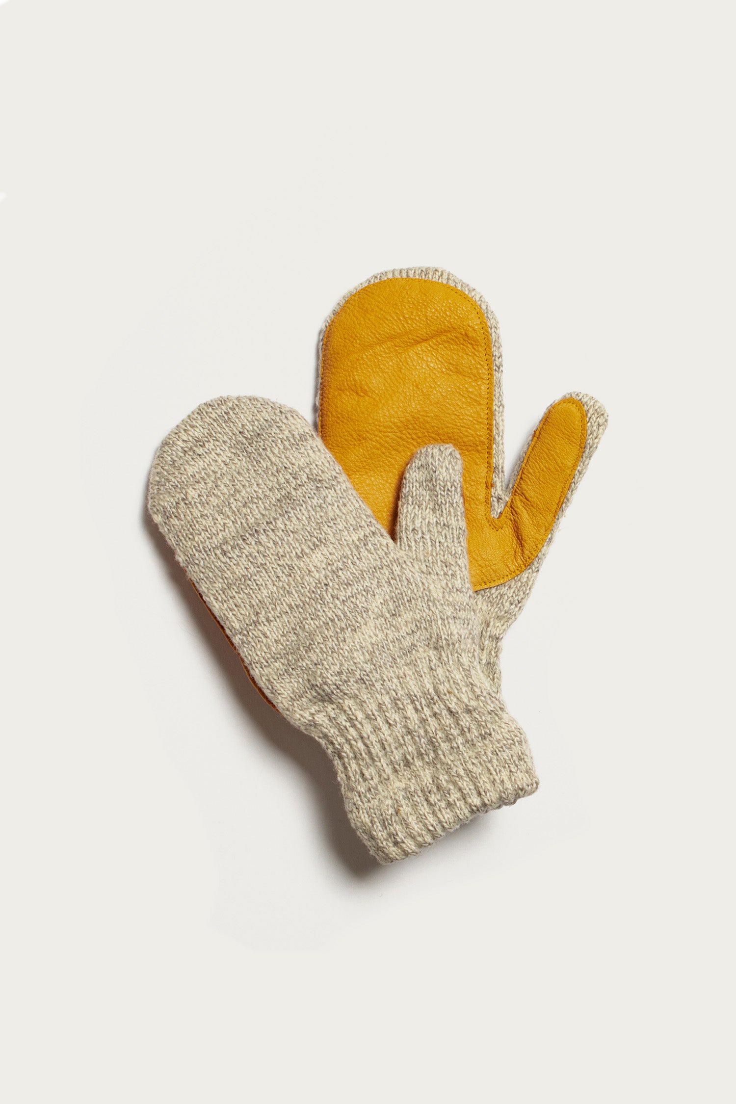 The Bridge & Burn Ragg Wool Lined Mitten in Oatmeal features cream-colored knit with a brown leather palm, made in the USA, shown on a white background.