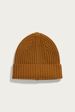 The Bridge & Burn Chunky Ribbed Beanie in Warm Ochre features a folded brim and is crafted from soft merino wool, shown against a plain white background.