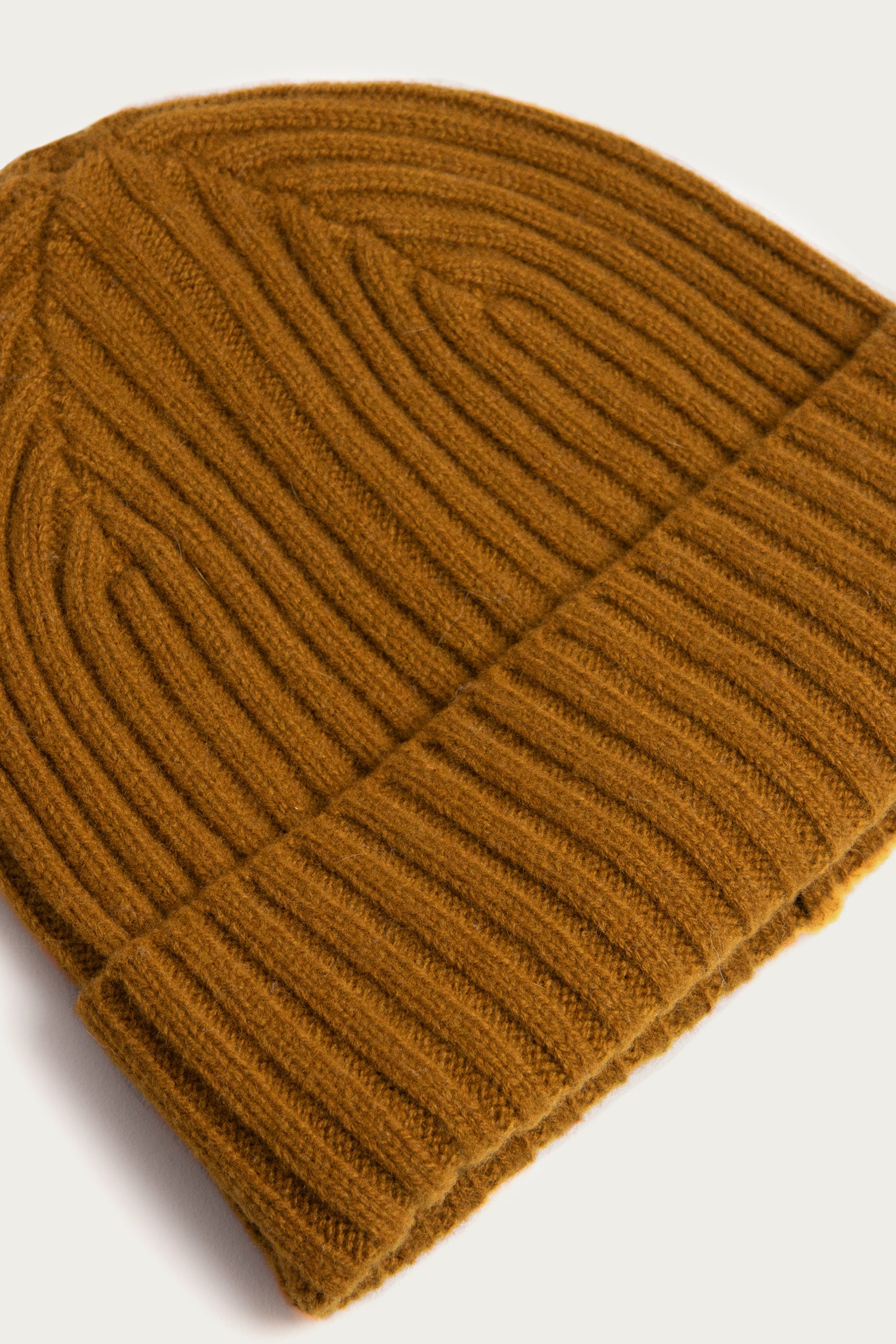A close-up of the Bridge & Burn Chunky Ribbed Beanie in Warm Ochre, featuring a folded brim and textured knit, displayed on a white background.