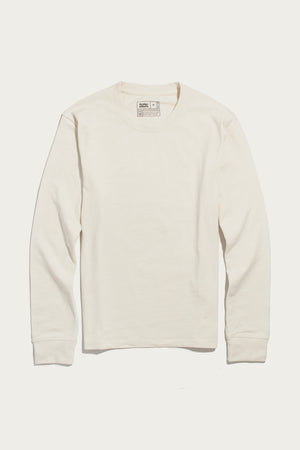 The Bridge & Burn Barney Long Sleeve Tee in Ivory, a relaxed fit crew neck shirt with long sleeves, is laid flat on a white background. Made from recycled cotton, it features visible cuffs and a neck tag.