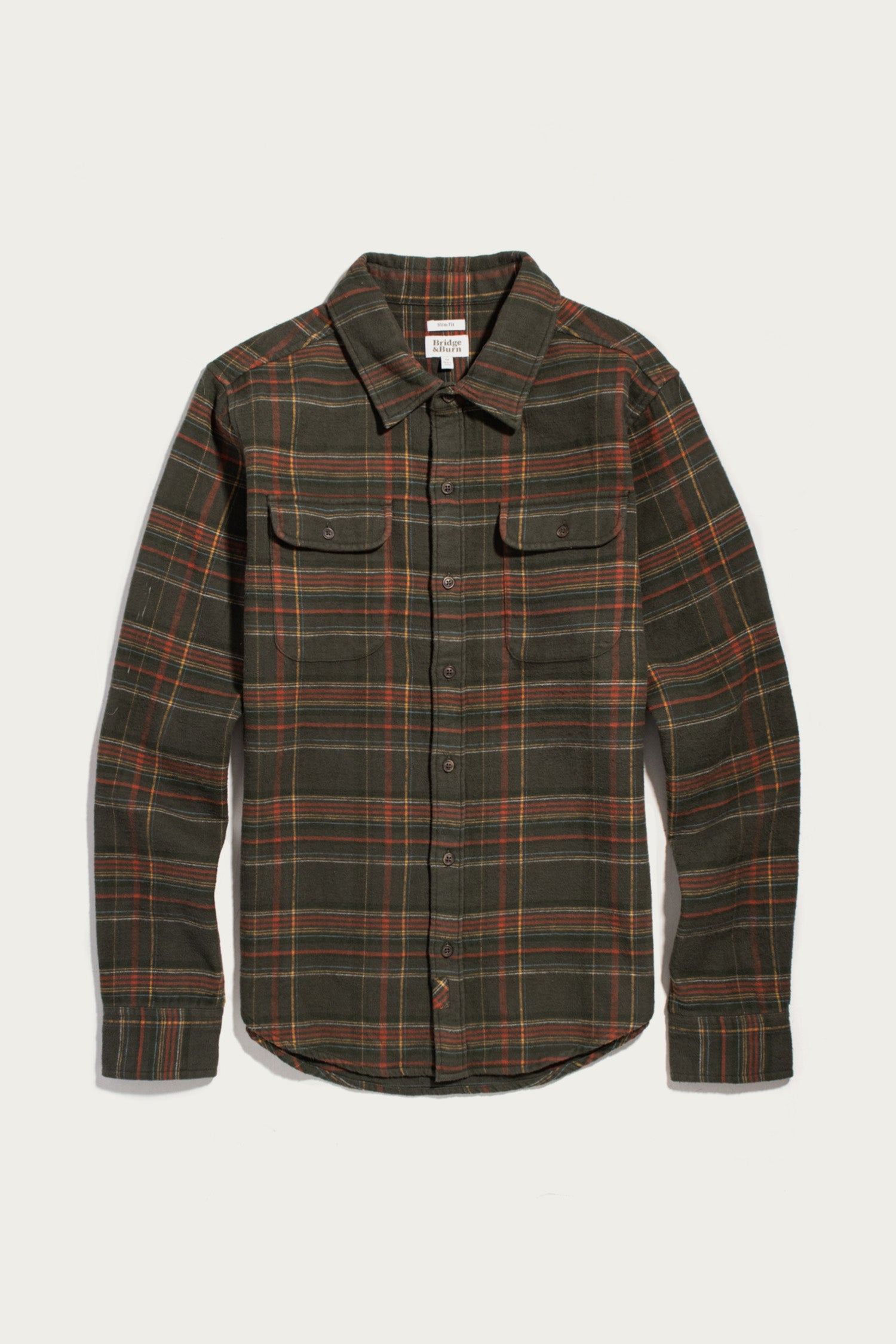 Bridge & Burn Cole Slim Shirt in Timberline Plaid: a slim-fit, long-sleeved button-down shirt in a dark green, orange, and yellow plaid pattern with two button-flap chest pockets.