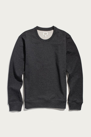 The Hayden Crew Sweatshirt in Graphite by Bridge & Burn is a plain dark gray crew neck sweatshirt with long sleeves and ribbed cuffs, crafted from soft recycled cotton, displayed on a white background.