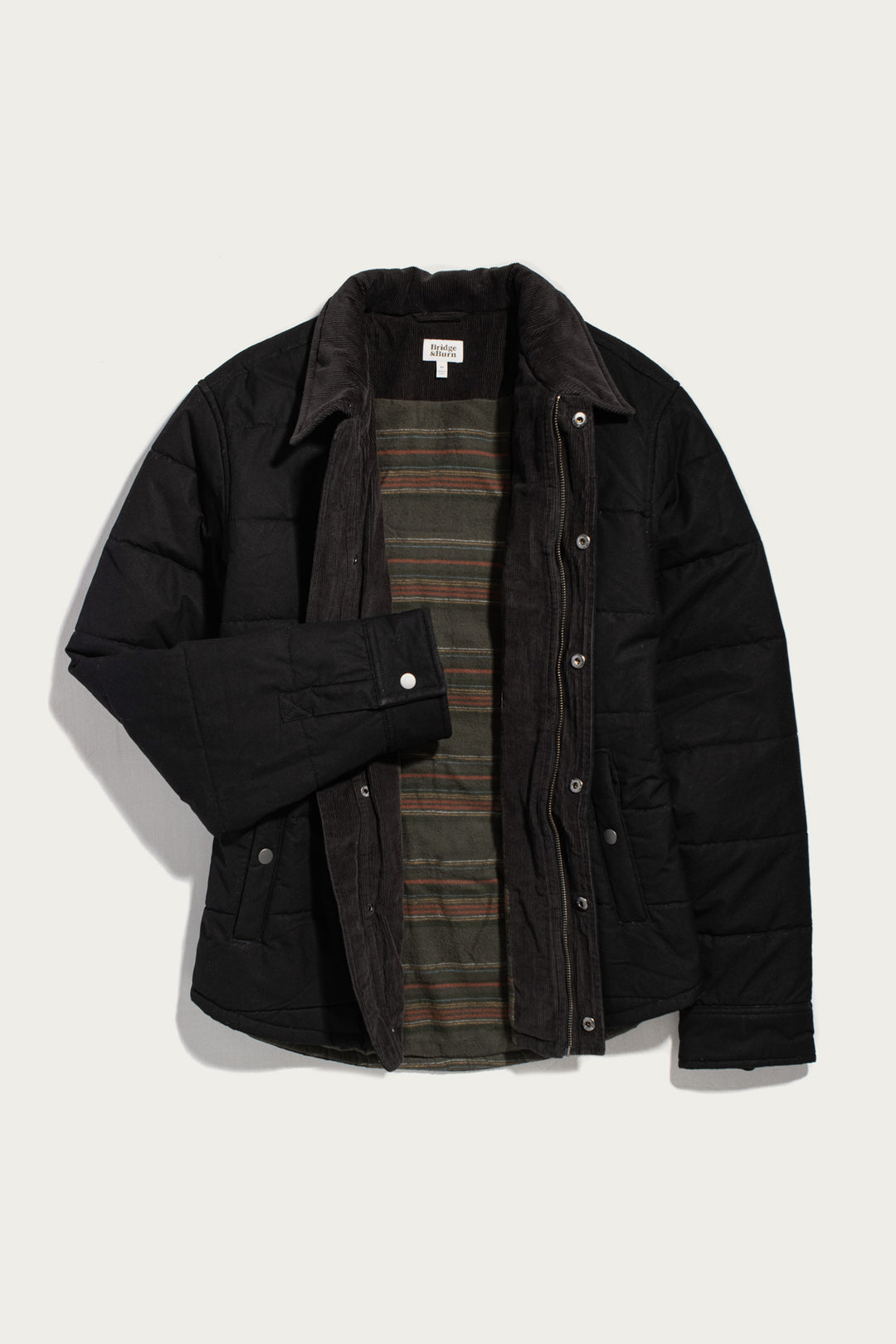 Bridge & Burn Holman Quilted Jacket in black canvas, featuring a quilted texture, corduroy collar, and striped inner lining.
