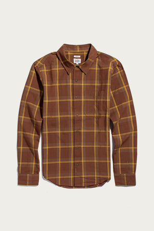 The Larson Shirt in Harvest Plaid by Bridge & Burn is a long-sleeve, classic fit button-up crafted from organic cotton, featuring a brown and yellow brushed flannel plaid pattern with a chest pocket. The shirt is shown laid flat against a white background.