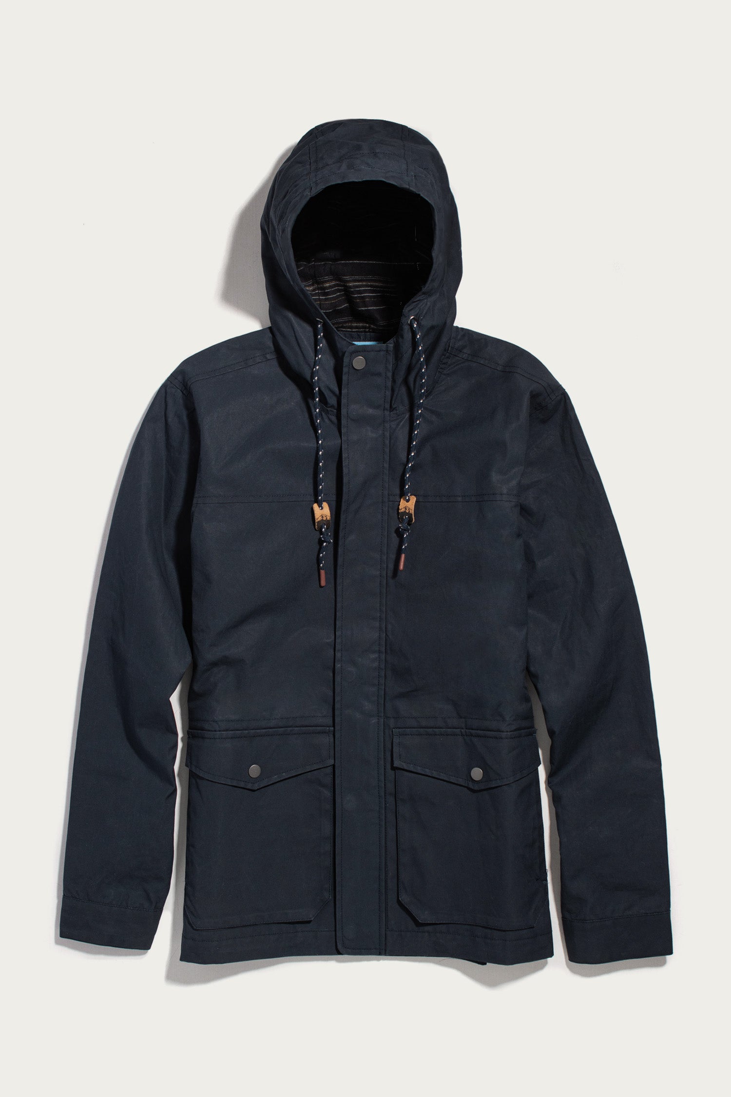 Bridge & Burn Marshall Jacket in navy waxed canvas with a front zipper, snap-button flap pockets, and speckled drawstring cords.