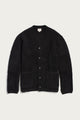 The Mateo Cardigan in Black by Bridge & Burn is displayed laid flat on a light background. This V-neck cardigan features patch pockets, a soft textured knit fabric, and a classic button-up design that offers both comfort and style.